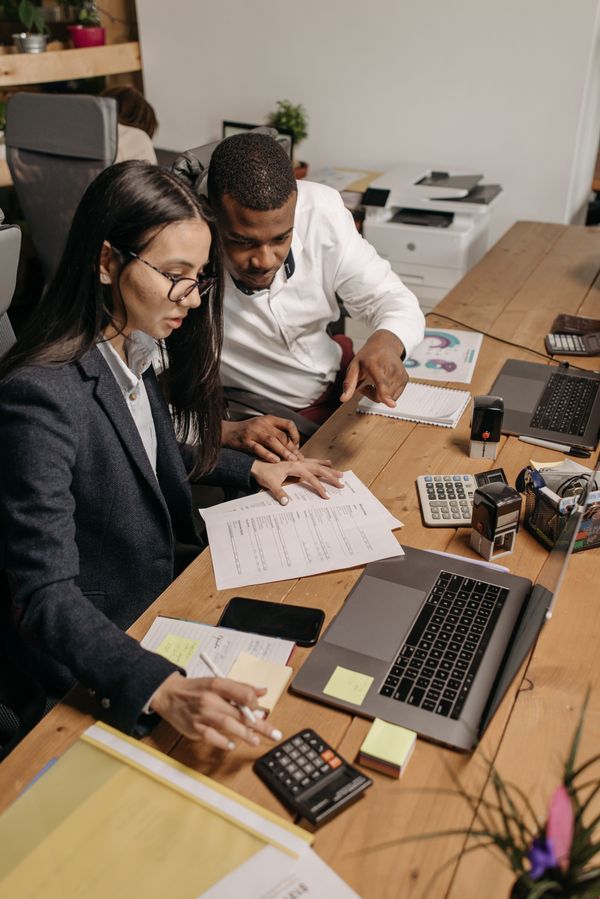 Contadores trabalhando em documentos financeiros com notebook